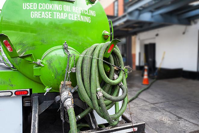 a grease trap pumping truck at a restaurant in Lansing